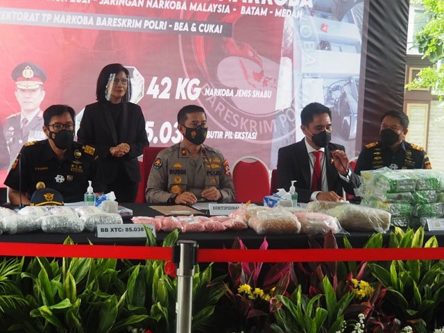 40 paket kemasan teh China , Daftar Pencarian Orang , dua paket besar berisi pil , hasil operasi gabungan , petugas menangkap dua tersangka